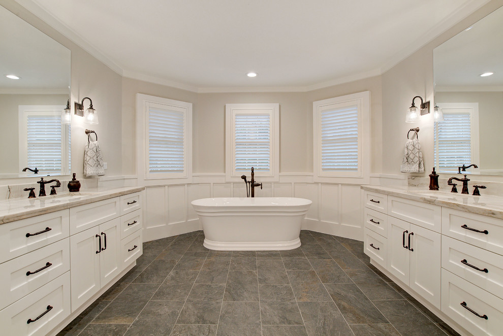 Example of a country master white tile and ceramic tile porcelain tile and gray floor bathroom design in Houston with shaker cabinets, white cabinets, a one-piece toilet, white walls, an undermount sink, quartzite countertops, a hinged shower door and white countertops