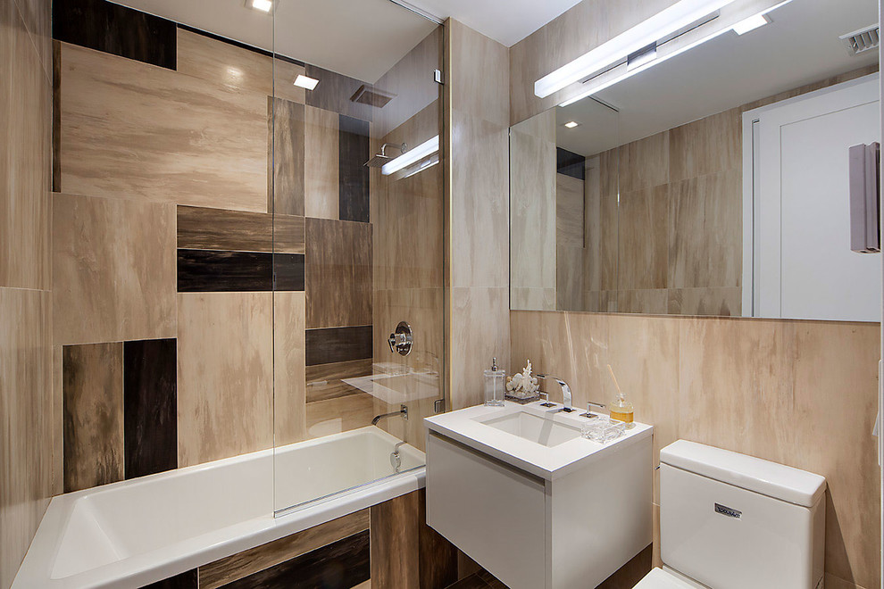 Industriell inredning av ett badrum med dusch, med släta luckor, vita skåp, ett platsbyggt badkar, en dusch/badkar-kombination, en toalettstol med separat cisternkåpa, flerfärgad kakel och ett undermonterad handfat