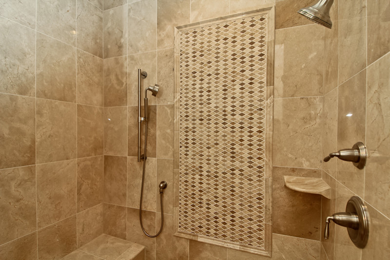 Cette photo montre une salle de bain principale chic avec une douche double et un carrelage beige.