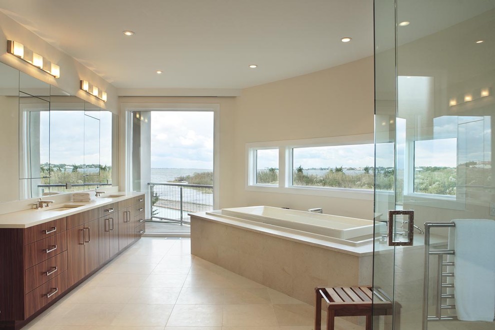Exemple d'une salle de bain tendance avec un lavabo encastré, une baignoire posée et du carrelage en travertin.