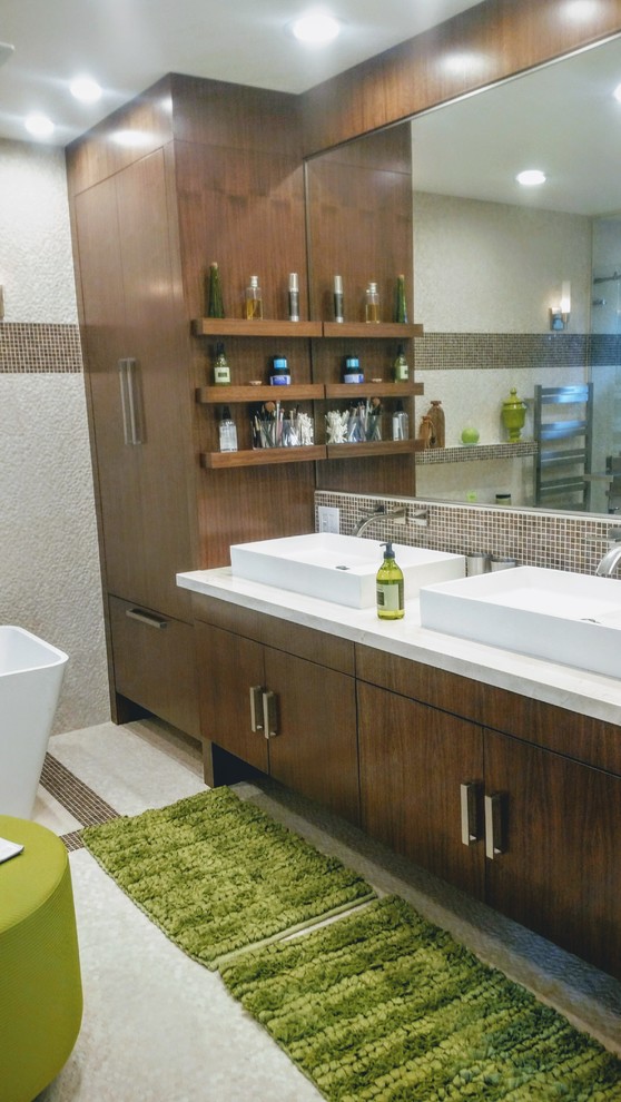 Exempel på ett mellanstort modernt en-suite badrum, med släta luckor, skåp i mellenmörkt trä, ett fristående badkar, brun kakel, glaskakel, ett fristående handfat, bänkskiva i kvartsit och beiget golv