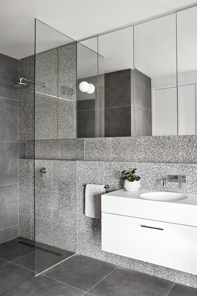 Inspiration för ett mellanstort funkis vit vitt badrum med dusch, med släta luckor, vita skåp, en öppen dusch, grå kakel, klinkergolv i porslin, ett integrerad handfat, grått golv och med dusch som är öppen