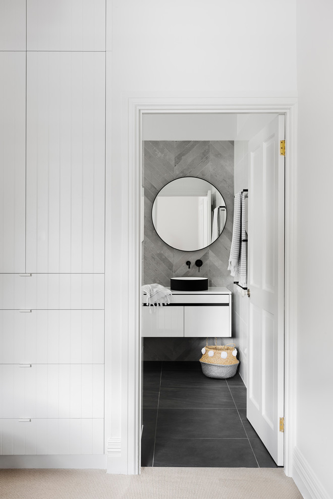 Inspiration for a medium sized contemporary ensuite wet room bathroom in Melbourne with flat-panel cabinets, white cabinets, a freestanding bath, a wall mounted toilet, white tiles, cement tiles, a vessel sink and engineered stone worktops.