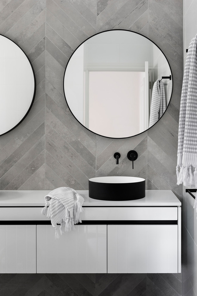 Example of a mid-sized trendy master white tile and cement tile bathroom design in Melbourne with flat-panel cabinets, white cabinets, a wall-mount toilet, a vessel sink and quartz countertops