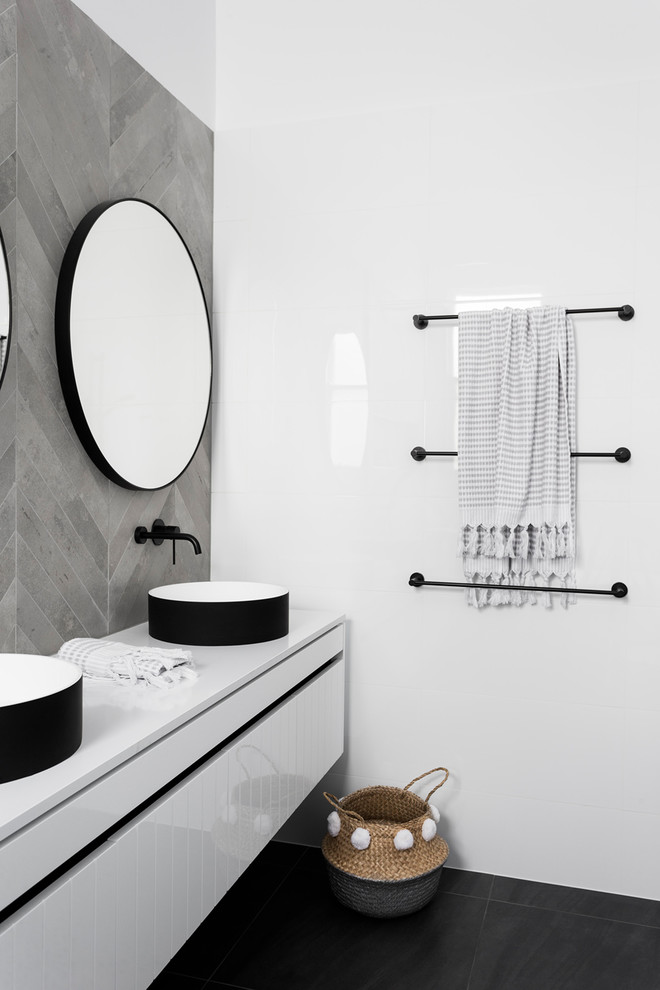 Inredning av ett modernt mellanstort grå grått en-suite badrum, med släta luckor, vita skåp, ett fristående badkar, våtrum, en vägghängd toalettstol, vit kakel, cementkakel, ett fristående handfat och bänkskiva i kvarts