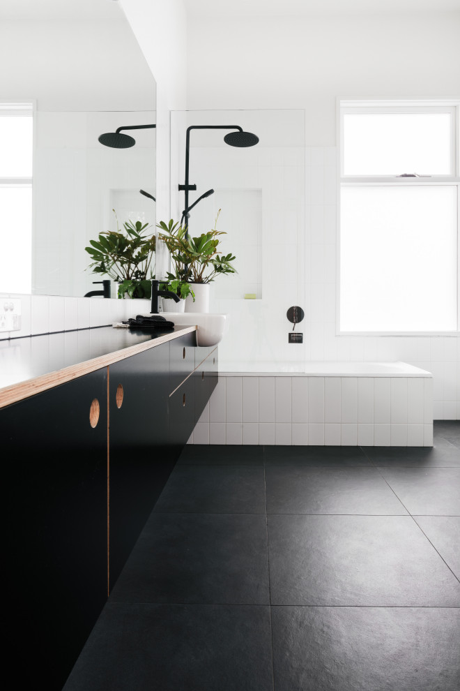 Exemple d'une salle de bain tendance avec un placard à porte plane, des portes de placard noires, un carrelage blanc, un mur blanc, une vasque, un plan de toilette en bois, un sol noir, un plan de toilette noir, meuble simple vasque et meuble-lavabo suspendu.
