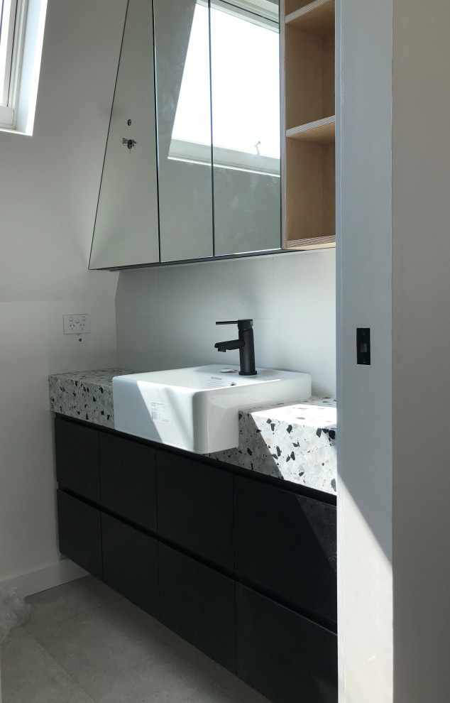 Inspiration för ett litet funkis grå grått en-suite badrum, med luckor med upphöjd panel, svarta skåp, en toalettstol med hel cisternkåpa, vit kakel, keramikplattor, vita väggar, ett integrerad handfat, bänkskiva i terrazo och grått golv