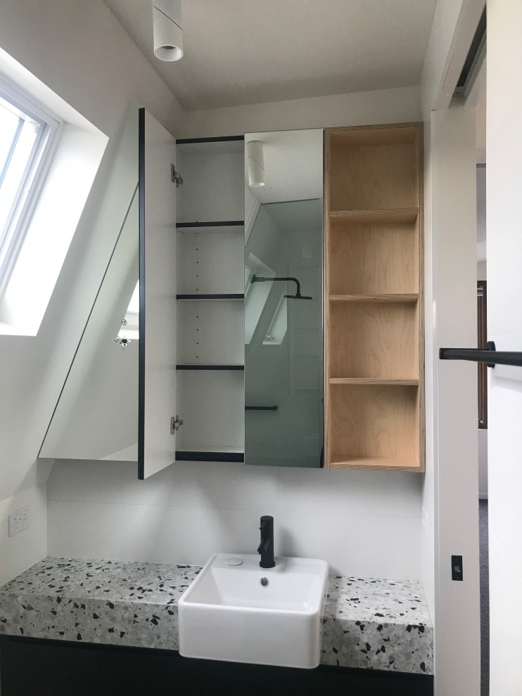 Exempel på ett litet modernt grå grått en-suite badrum, med luckor med upphöjd panel, svarta skåp, en toalettstol med hel cisternkåpa, vit kakel, keramikplattor, vita väggar, ett integrerad handfat, bänkskiva i terrazo och grått golv