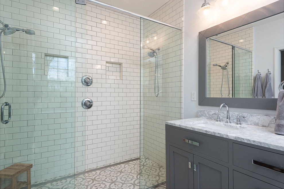 Example of a mid-sized transitional master white tile and subway tile porcelain tile walk-in shower design in Other with shaker cabinets, gray cabinets, a two-piece toilet, white walls, an undermount sink, marble countertops and a hinged shower door