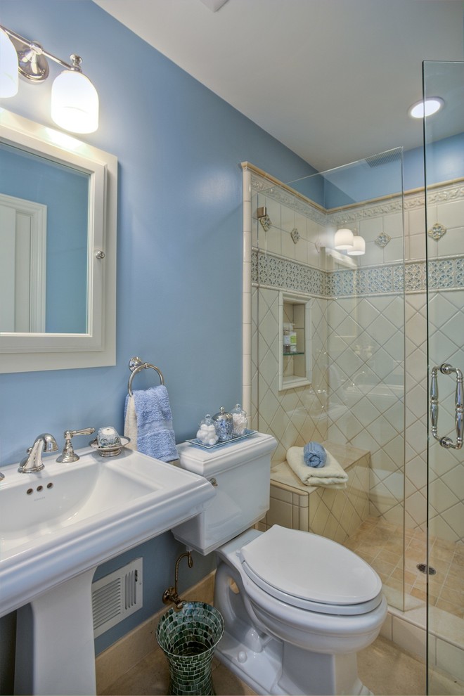 Modelo de cuarto de baño tradicional pequeño con lavabo con pedestal, ducha empotrada, sanitario de dos piezas, baldosas y/o azulejos beige, baldosas y/o azulejos de porcelana, paredes azules, suelo de baldosas de porcelana y aseo y ducha