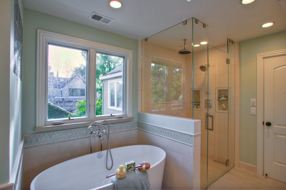 This is an example of a large classic ensuite bathroom in San Francisco with a submerged sink, beaded cabinets, white cabinets, limestone worktops, a freestanding bath, a built-in shower, a one-piece toilet, beige tiles, glass tiles, green walls and ceramic flooring.