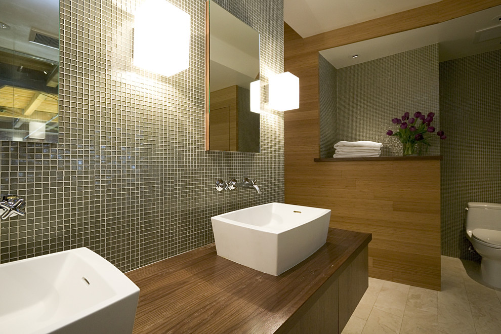 На фото: ванная комната: освещение в стиле модернизм с плиткой мозаикой, настольной раковиной и столешницей из дерева с