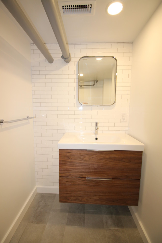 Small traditional shower room bathroom in Philadelphia with freestanding cabinets, white cabinets, an alcove shower, a two-piece toilet, white tiles, white walls, porcelain flooring, a wall-mounted sink, grey floors and a hinged door.
