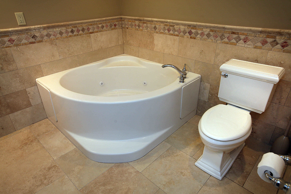 Cette image montre une grande salle de bain traditionnelle avec un bain bouillonnant, WC séparés, un carrelage de pierre et un sol en travertin.