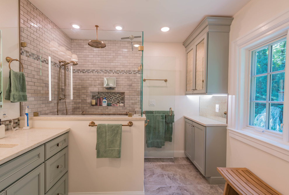 This is an example of a medium sized classic ensuite bathroom in Philadelphia with freestanding cabinets, green cabinets, a corner shower, a one-piece toilet, beige tiles, marble tiles, grey walls, porcelain flooring, a submerged sink, engineered stone worktops, beige floors, a hinged door and beige worktops.