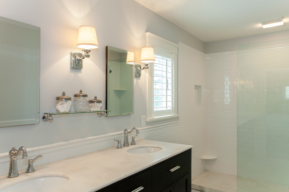 This is an example of a medium sized traditional ensuite bathroom in Philadelphia with a submerged sink, flat-panel cabinets, dark wood cabinets, a walk-in shower, a one-piece toilet, white tiles, metro tiles, grey walls and marble flooring.