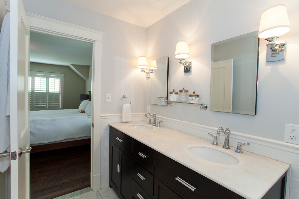 Modelo de cuarto de baño principal clásico de tamaño medio con lavabo bajoencimera, armarios con paneles lisos, puertas de armario de madera en tonos medios, ducha abierta, paredes grises y suelo de mármol