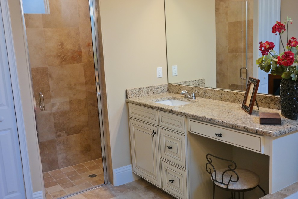 Inredning av ett amerikanskt en-suite badrum, med luckor med upphöjd panel, beige skåp, beige kakel, stenkakel, beige väggar, travertin golv, ett nedsänkt handfat, granitbänkskiva, ett hörnbadkar, en dusch i en alkov och en toalettstol med hel cisternkåpa