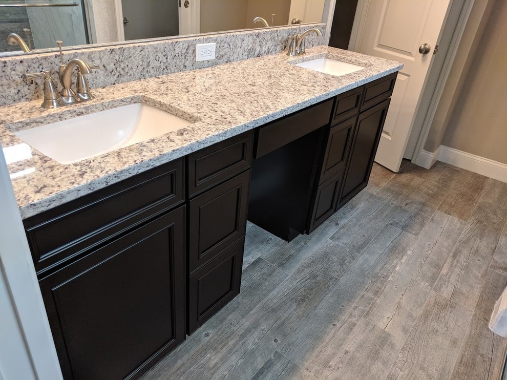 Inspiration for a medium sized contemporary ensuite bathroom in Orlando with recessed-panel cabinets, dark wood cabinets, a corner shower, a one-piece toilet, white tiles, marble tiles, grey walls, porcelain flooring, a submerged sink, granite worktops, grey floors, a sliding door and grey worktops.