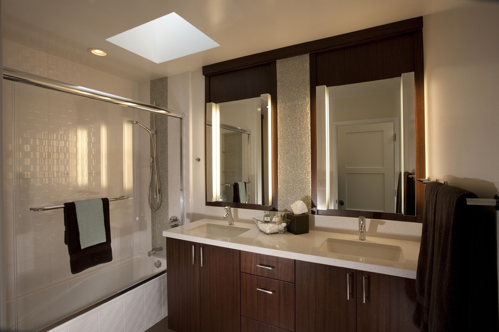 Стильный дизайн: ванная комната в современном стиле с врезной раковиной, плоскими фасадами, темными деревянными фасадами, ванной в нише, душем над ванной и белой плиткой - последний тренд