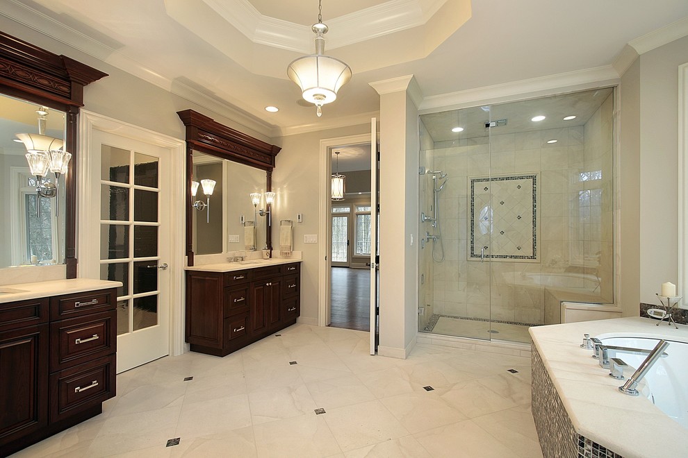 Large transitional master beige tile and porcelain tile porcelain tile corner shower photo in Atlanta with an undermount sink, raised-panel cabinets, medium tone wood cabinets, marble countertops, an undermount tub, a one-piece toilet and multicolored walls