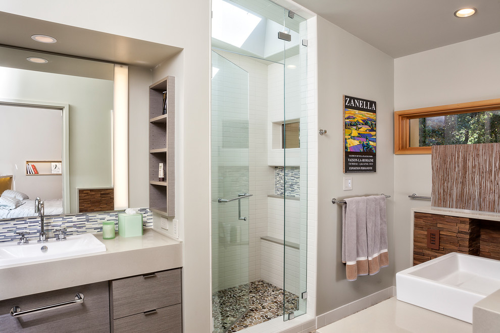 Foto på ett mellanstort funkis badrum, med ett nedsänkt handfat, släta luckor, grå skåp, en dusch i en alkov, vita väggar, ett fristående badkar, en toalettstol med separat cisternkåpa, flerfärgad kakel och brunt golv