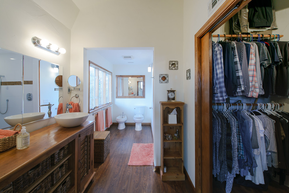 Idéer för ett medelhavsstil en-suite badrum, med skåp i mellenmörkt trä, en bidé, vita väggar, ett fristående handfat, träbänkskiva, brunt golv, mellanmörkt trägolv och luckor med lamellpanel