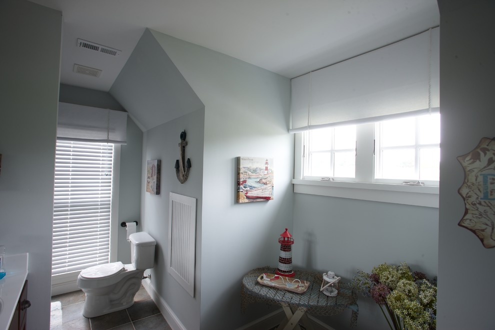 Cette photo montre une salle d'eau chic de taille moyenne avec WC à poser, un mur gris, un sol en carrelage de céramique, un lavabo encastré et un plan de toilette en surface solide.