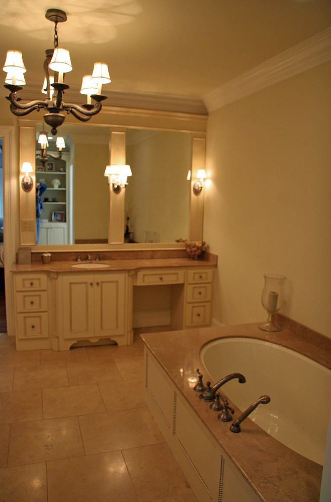 Photo of a medium sized classic ensuite bathroom in Atlanta with recessed-panel cabinets, beige cabinets, a submerged bath, beige walls, ceramic flooring, a submerged sink, soapstone worktops and beige floors.