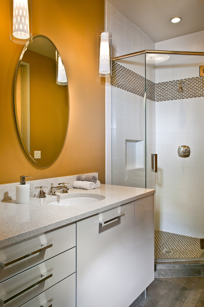 Идея дизайна: маленькая ванная комната в современном стиле с угловым душем, плоскими фасадами, белой плиткой, душевой кабиной, бежевыми фасадами, унитазом-моноблоком, керамогранитной плиткой, коричневыми стенами, полом из известняка, врезной раковиной, столешницей из искусственного кварца, коричневым полом, душем с распашными дверями и серой столешницей для на участке и в саду