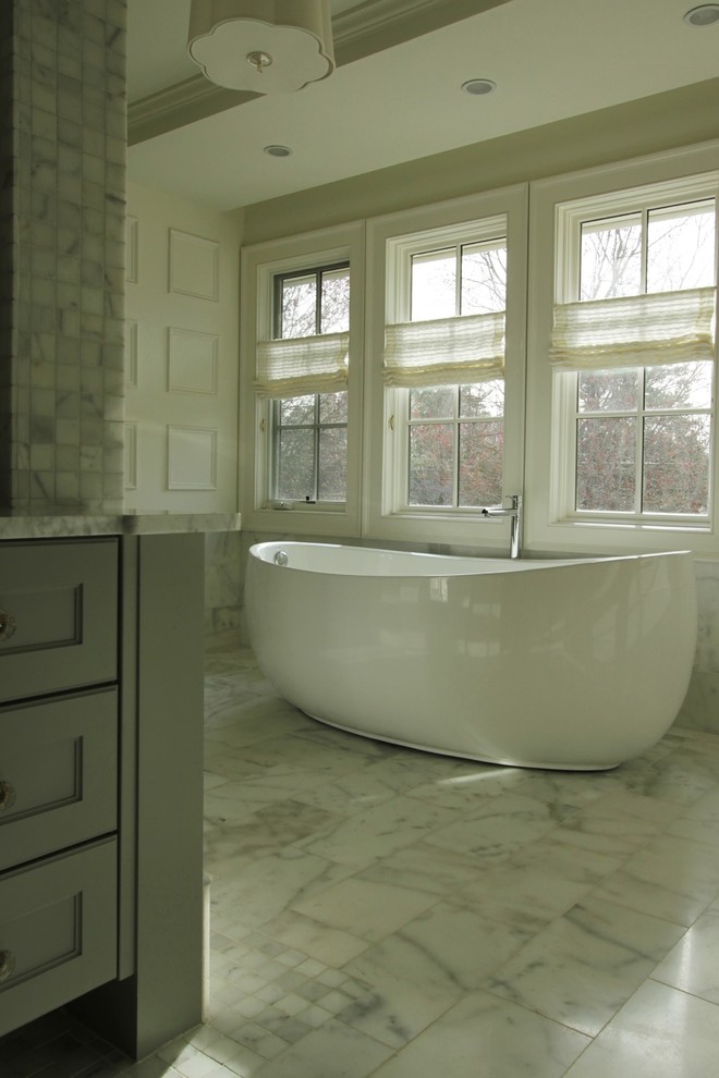 Идея дизайна: главная ванная комната среднего размера в стиле неоклассика (современная классика) с фасадами с утопленной филенкой, серыми фасадами, отдельно стоящей ванной, белой плиткой, каменной плиткой, белыми стенами, мраморным полом и столешницей из кварцита