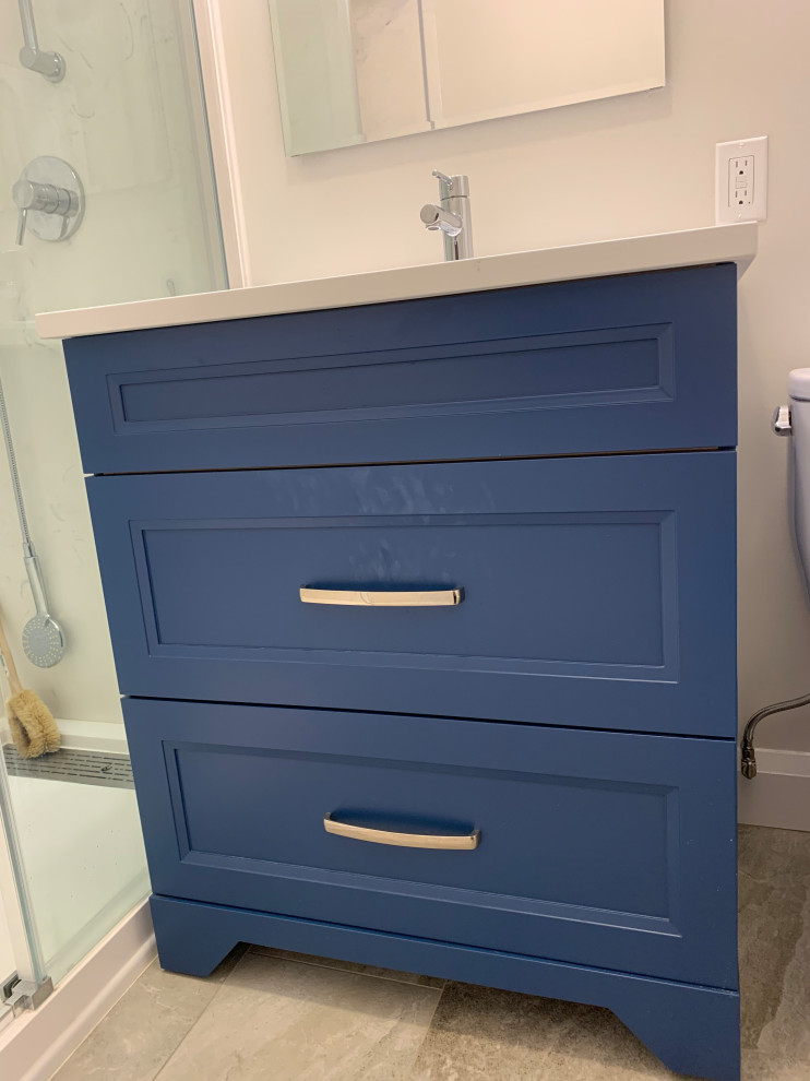 Small trendy ceramic tile and single-sink bathroom photo in Toronto with recessed-panel cabinets, blue cabinets, a two-piece toilet, an undermount sink, quartzite countertops, white countertops and a freestanding vanity