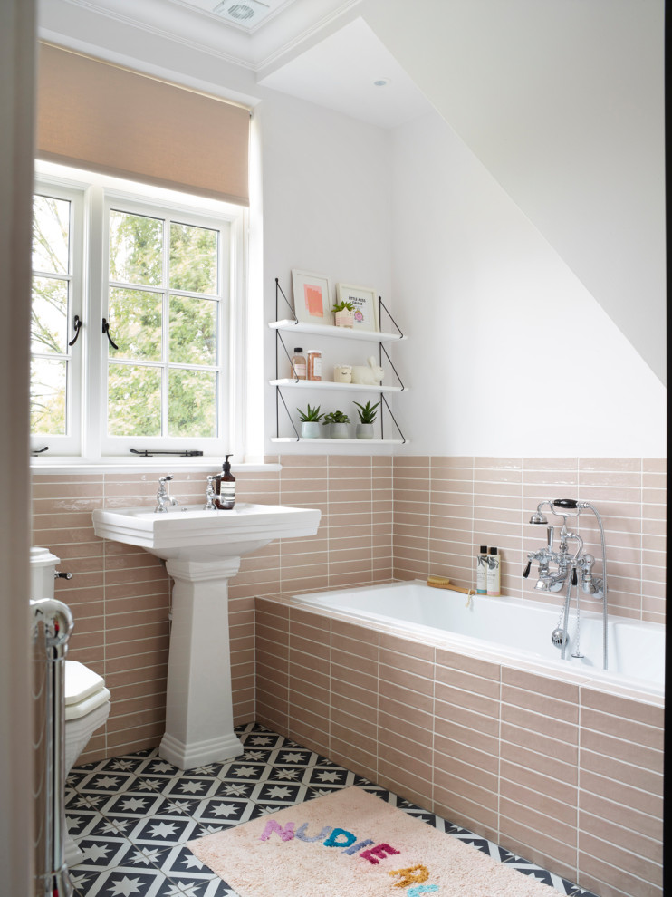 Mittelgroßes Klassisches Duschbad mit Einbaubadewanne, Wandtoilette mit Spülkasten, beigen Fliesen, Porzellanfliesen, weißer Wandfarbe, Sockelwaschbecken, buntem Boden, weißer Waschtischplatte, Einzelwaschbecken und eingebautem Waschtisch in Buckinghamshire