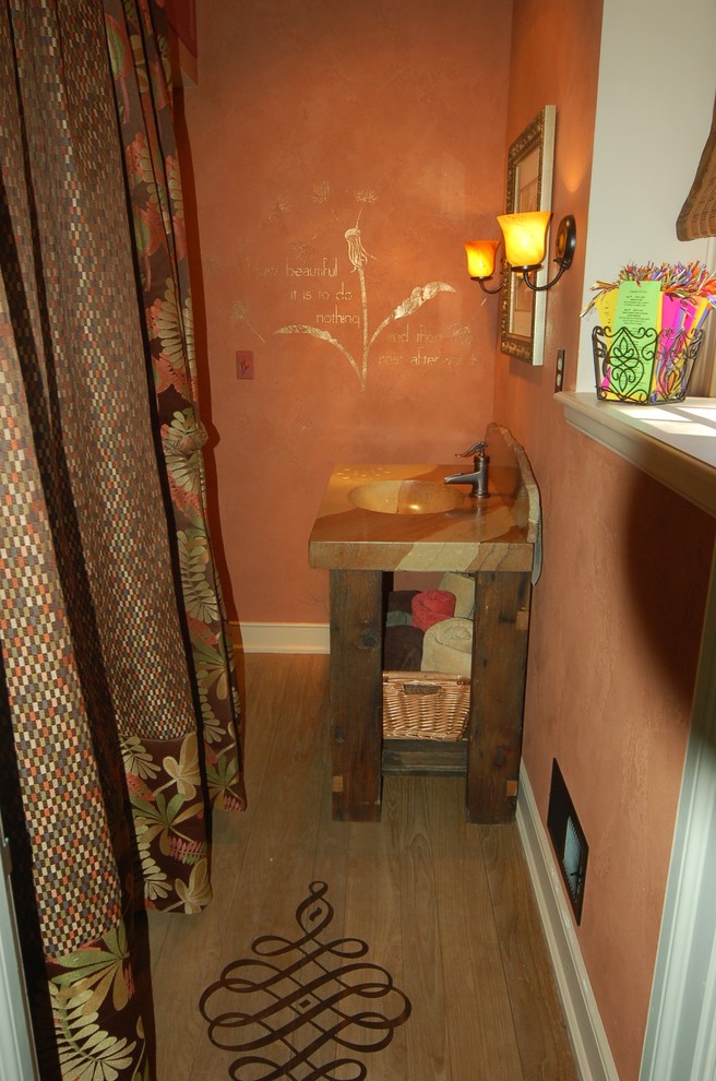 Exemple d'une petite douche en alcôve principale éclectique en bois foncé avec un lavabo intégré, un placard sans porte, un plan de toilette en béton, une baignoire en alcôve, WC séparés, un mur orange et parquet clair.