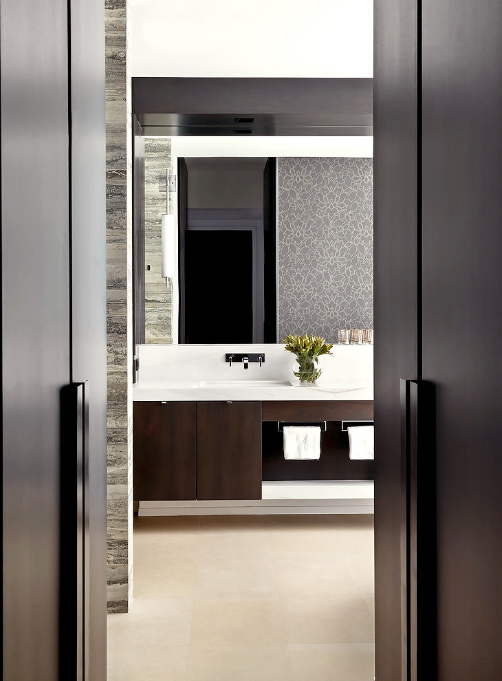 Пример оригинального дизайна: главная ванная комната среднего размера в стиле модернизм с плоскими фасадами, темными деревянными фасадами, отдельно стоящей ванной, раздельным унитазом, серой плиткой, каменной плиткой, серыми стенами, полом из известняка, врезной раковиной, мраморной столешницей, душем в нише, бежевым полом, душем с распашными дверями и белой столешницей