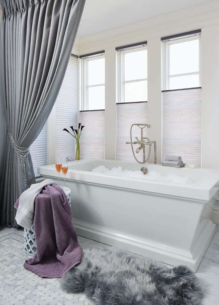Inredning av ett modernt mellanstort badrum, med ett fristående badkar, vita väggar, marmorgolv och flerfärgat golv
