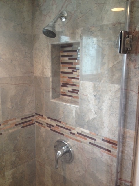 Example of a mid-sized trendy master brown tile and stone tile porcelain tile alcove shower design in Orange County with an undermount sink, raised-panel cabinets, dark wood cabinets, marble countertops, a two-piece toilet and brown walls