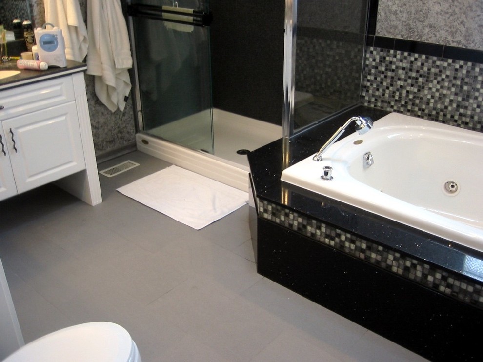 Cette image montre une salle de bain principale design de taille moyenne avec un placard avec porte à panneau surélevé, des portes de placard blanches, un bain bouillonnant, une douche d'angle, un carrelage noir, un carrelage noir et blanc, un carrelage gris, un carrelage multicolore, un carrelage blanc, mosaïque, un mur gris, un sol en carrelage de porcelaine et un plan de toilette en quartz.