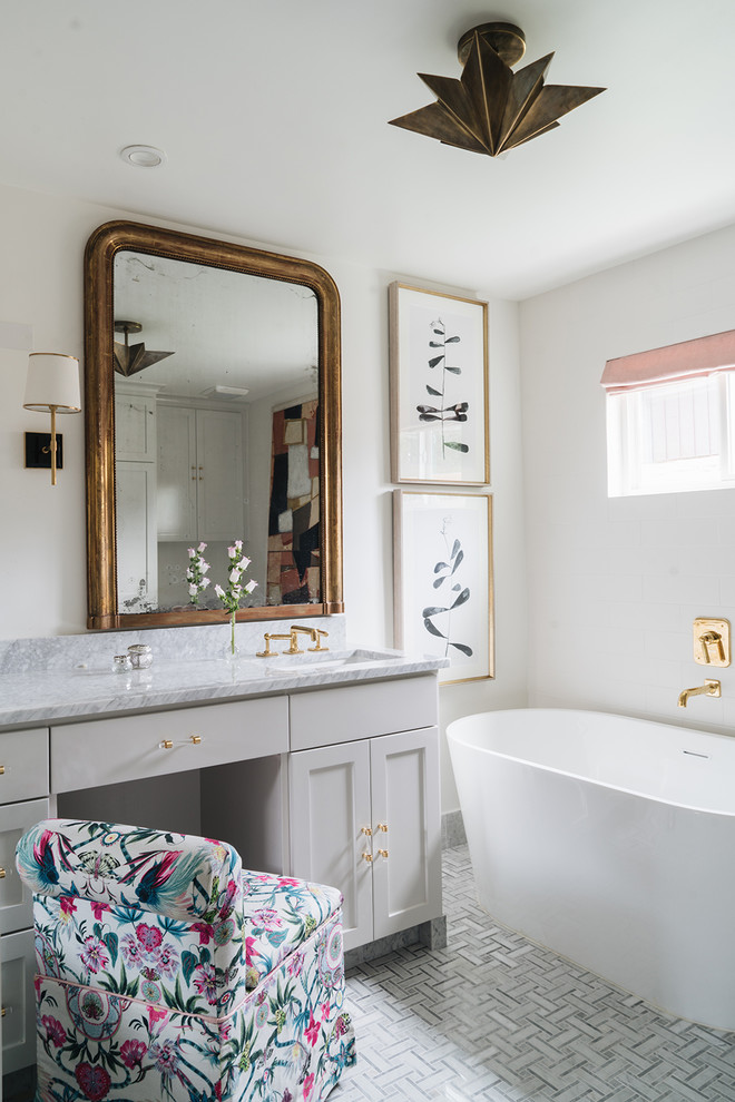 Aménagement d'une salle de bain principale classique avec un placard à porte shaker, des portes de placard grises, une baignoire indépendante, un mur blanc, un lavabo encastré, un plan de toilette en marbre, un sol gris et un plan de toilette gris.