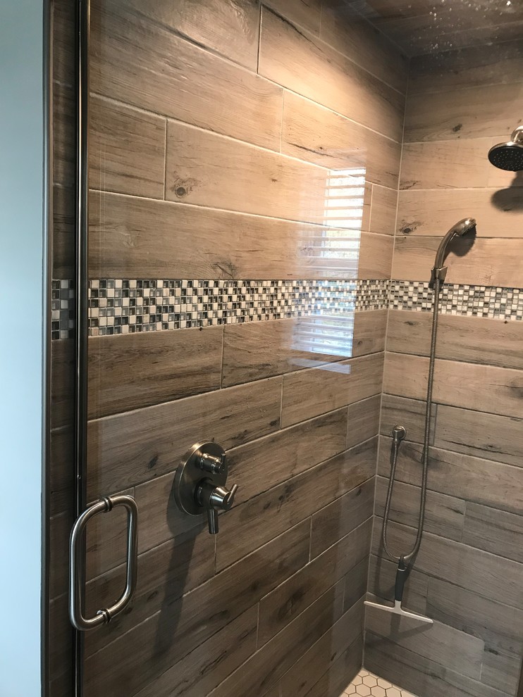 Example of a small trendy master gray tile and ceramic tile ceramic tile and gray floor wet room design in New York with flat-panel cabinets, white cabinets, beige walls, an undermount sink, granite countertops, a hinged shower door and black countertops