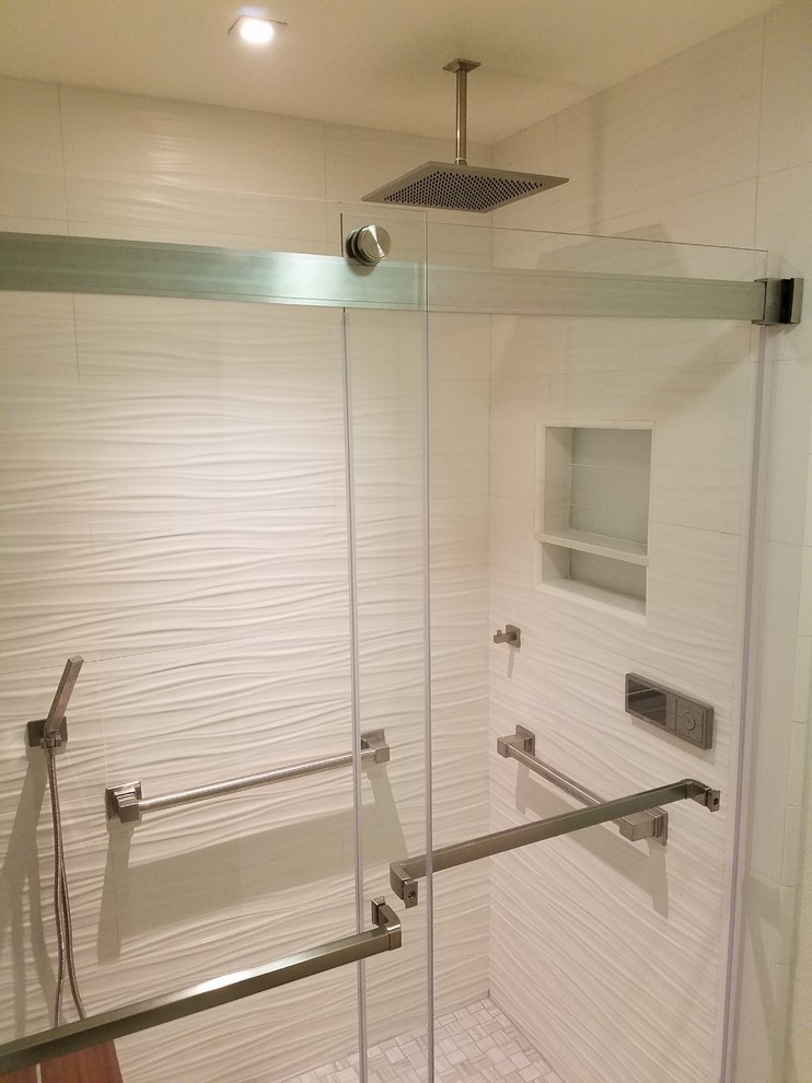 Cette photo montre une douche en alcôve chic avec un carrelage blanc, des carreaux de porcelaine et une cabine de douche à porte coulissante.