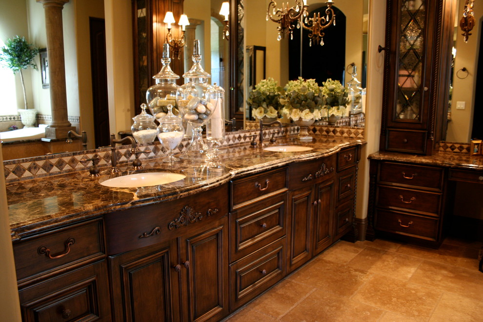 Photo of an expansive mediterranean ensuite bathroom in San Diego with flat-panel cabinets, dark wood cabinets, a built-in bath, a corner shower, beige tiles, stone tiles, beige walls, travertine flooring, a submerged sink and granite worktops.