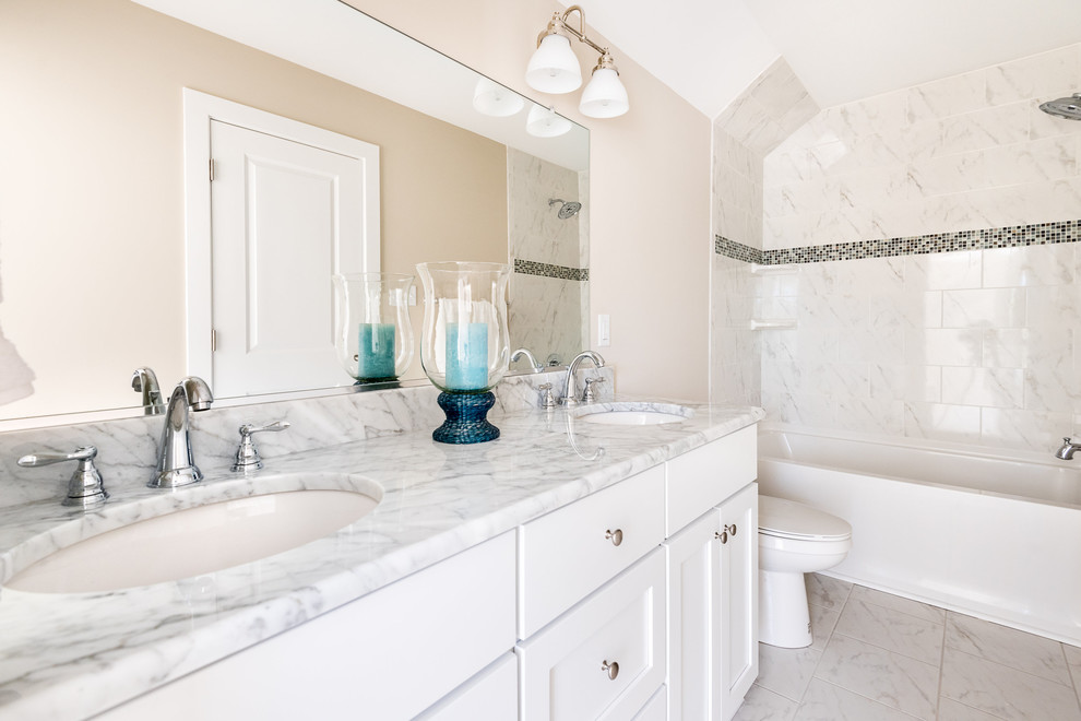 This is an example of a medium sized classic bathroom in Richmond with shaker cabinets, white cabinets, an alcove bath, a shower/bath combination, a two-piece toilet, grey tiles, white tiles, marble tiles, beige walls, marble flooring, a submerged sink and marble worktops.