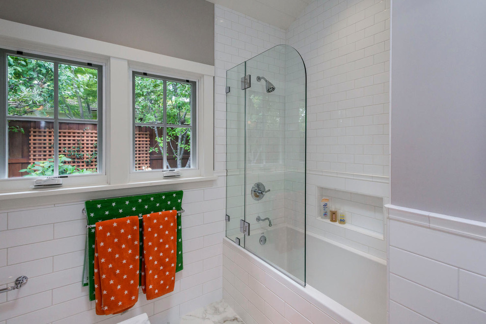 Tub/shower combo - large transitional kids' white tile and ceramic tile tub/shower combo idea in San Francisco with furniture-like cabinets, white cabinets, a wall-mount toilet, gray walls, an undermount sink and marble countertops