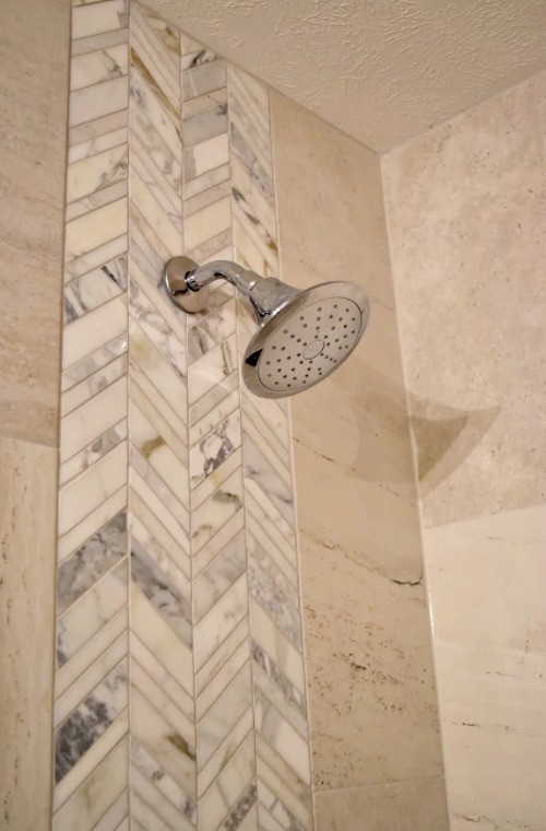 Cette photo montre une douche en alcôve chic de taille moyenne avec du carrelage en pierre calcaire et une cabine de douche à porte battante.
