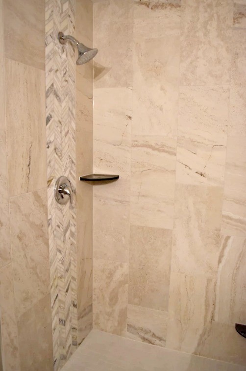他の地域にある中くらいなトランジショナルスタイルのおしゃれな浴室 (アルコーブ型シャワー、ライムストーンタイル、アンダーカウンター洗面器、御影石の洗面台、開き戸のシャワー) の写真