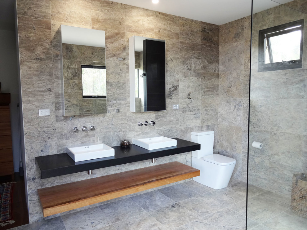 Ispirazione per una grande stanza da bagno padronale moderna con doccia aperta, WC sospeso, piastrelle in travertino, top in granito e doccia aperta