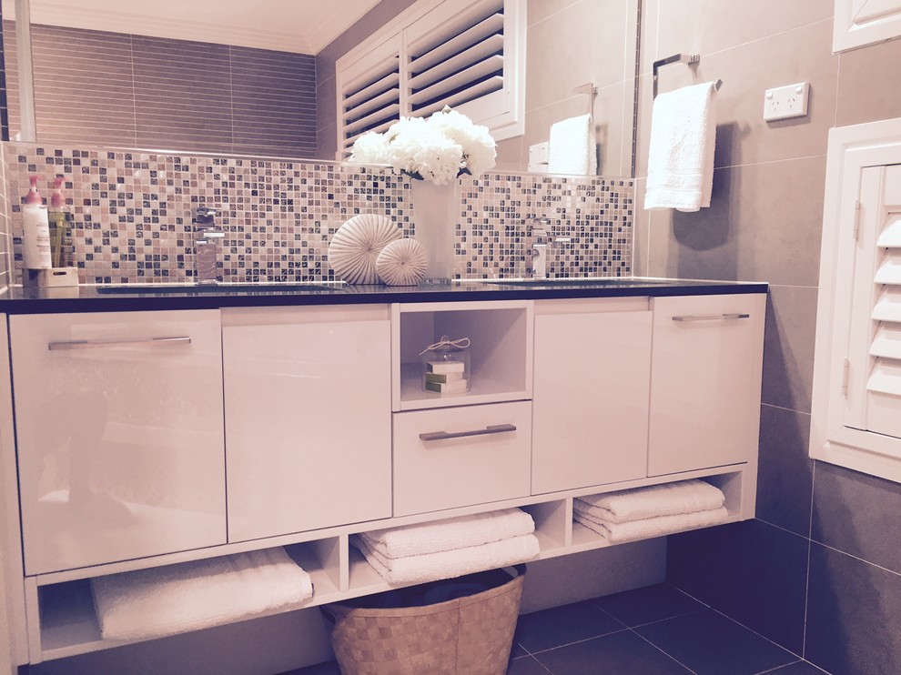 Esempio di una stanza da bagno minimal con lavabo sottopiano, top in pietra calcarea, vasca idromassaggio, doccia doppia, WC sospeso, piastrelle beige, piastrelle in gres porcellanato, pareti beige e pavimento in gres porcellanato