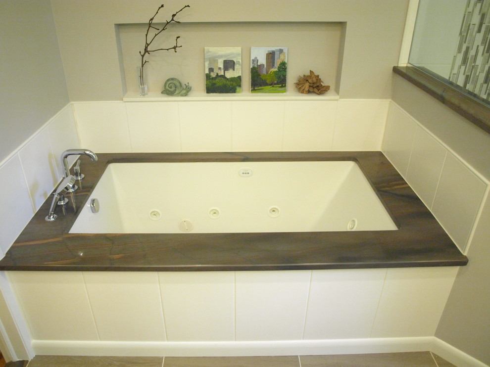 Пример оригинального дизайна: главная ванная комната среднего размера в стиле неоклассика (современная классика) с фасадами с утопленной филенкой, белыми фасадами, ванной в нише, угловым душем, унитазом-моноблоком, серыми стенами, серым полом, душем с распашными дверями, бежевой плиткой, керамической плиткой, полом из ламината, врезной раковиной и столешницей из гранита
