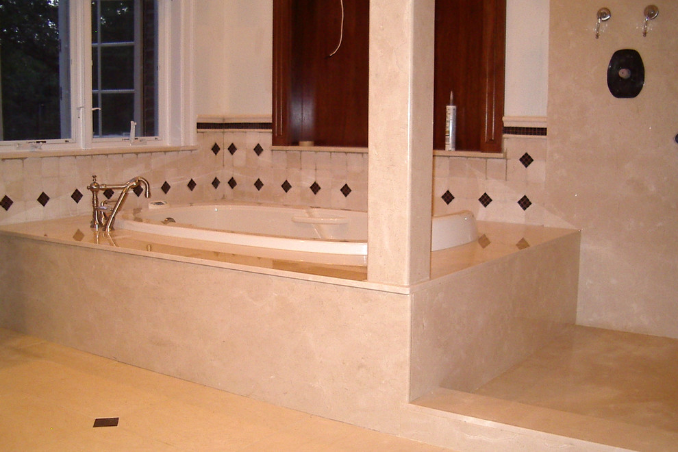 Immagine di una grande stanza da bagno padronale classica con vasca da incasso, piastrelle beige, piastrelle in pietra, pareti beige e pavimento in marmo